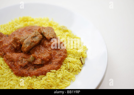 Le style indien authentique Curry Rogan Josh d'agneau avec riz Pilau aromatique jaune et pas de personnes Banque D'Images
