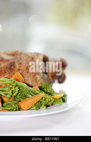 Les frais Gigot d'agneau avec des légumes y compris le brocoli et les carottes isolé sur un fond blanc avec aucun peuple Banque D'Images