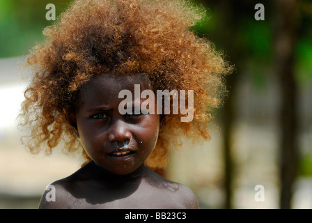 Îles Salomon. Le portrait d'une fille avec de longs mélanésienne et les cheveux blonds, les yeux d'un noir profond, comité permanent barechest Banque D'Images