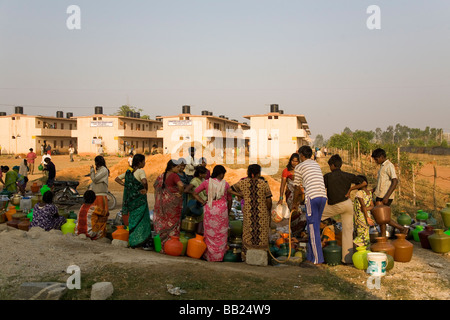 Hommes Femmes et enfants pour recueillir de la file d'une rehausse de Ware dans la banlieue de Bangalore, en Inde. Banque D'Images