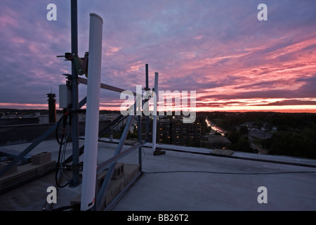 Des antennes cellulaires installées sur le toit-vu pendant le coucher du soleil Banque D'Images