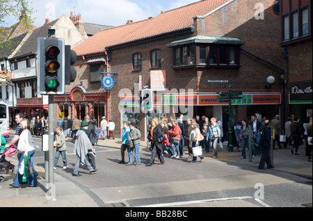 Les piétons à l'aide d'un passage pour piétons pour traverser la route alors que les feux sont au vert dans la région de York en Angleterre Banque D'Images