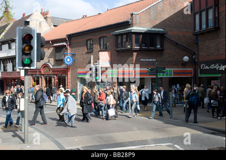 Les piétons à l'aide d'un passage pour piétons pour traverser la route alors que les feux sont au vert dans la région de York en Angleterre Banque D'Images