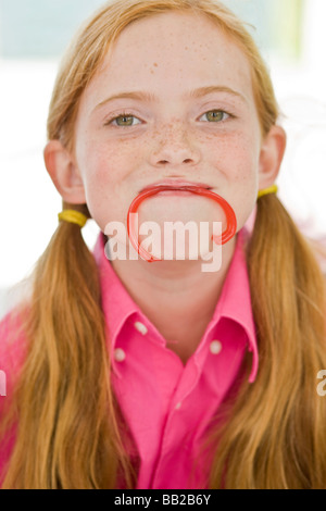 Portrait of a Girl holding a candy dans sa bouche Banque D'Images
