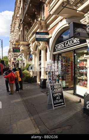 Les touristes en regardant une carte en dehors d'une carte postale et cadeaux sur Southampton Row, Bloomsbury, London, UK Banque D'Images