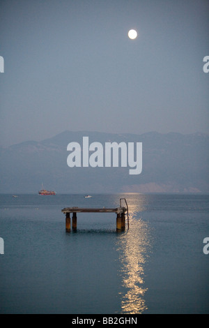 Voyages Croatie, la pleine lune se lève sur la mer Adriatique et une plateforme pour la baignade à Baska, sur l'île de Krk. Banque D'Images