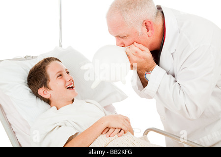 Funny médecin reçoit un enfant en faisant sauter un gant chirurgical isolated on white Banque D'Images