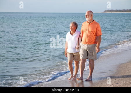 Happy senior couple bénéficie d'une promenade romantique sur la plage Banque D'Images