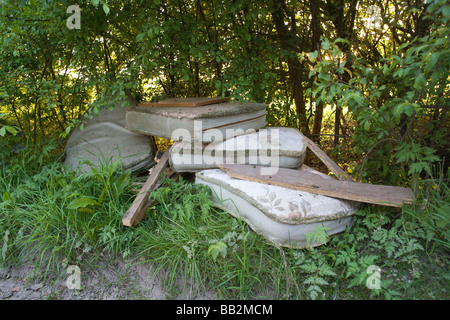 'Fly tipped' déchets (déchets) faisant illégalement sur le côté d'une route de campagne Banque D'Images