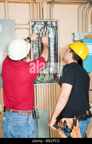 Apprenti électricien et l'évolution d'un coupe-circuit défectueux dans un groupe industriel Banque D'Images