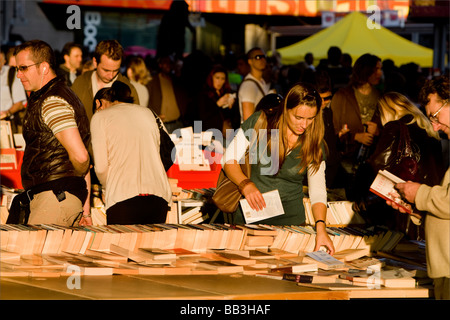Une femme parcourt des livres à un stand de livres sur la tamise southbank Banque D'Images