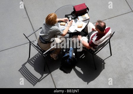 Regardant vers le bas sur deux touristes en train de manger un sandwich avec le california guide sur la table Horton Plaza San Diego États-Unis Banque D'Images