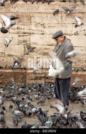 L'homme l'alimentation des pigeons à l'extérieur de la Yeni Cami dans Istanbul Eminönü Banque D'Images