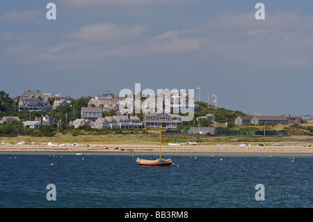 Amérique du Nord, USA, Massachusetts, Nantucket. Un bateau et les maisons sur la plage, dans le port de Nantucket Banque D'Images