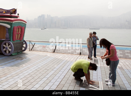 Les touristes placer ses mains en une plaque sur l'Avenue des Stars à Hong Kong Banque D'Images