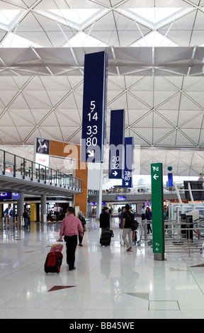 Les voyageurs ont vu dans le hall des départs à l'Aéroport International de Hong Kong Banque D'Images