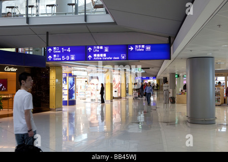 Les voyageurs ont vu dans le hall de départ de l'Aéroport International de Hong Kong Banque D'Images