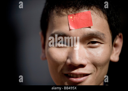 Un jeune homme a collé un drapeau chinois sur son front pour célébrer le relais de la flamme olympique dans sa ville natale dans le sud de la Ch Banque D'Images