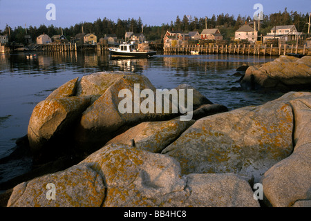 Un bateau moteurs au-delà d'un petit village côtier sur Mattinicus Island, Maine. Banque D'Images