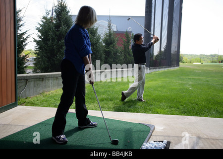 Une femme obtient une leçon de golf à partir d'un pro de golf Banque D'Images