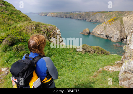 Une femelle Walker sur les DDIN Fawr, un promontoire de roche menant au chemin de la côte du Pembrokeshire, près de Solva, Pays de Galles, Royaume-Uni Banque D'Images