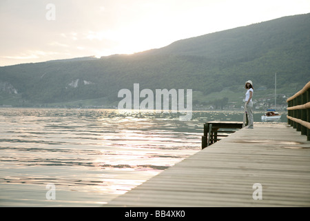 Femme debout sur une jetée au bord de lac Banque D'Images