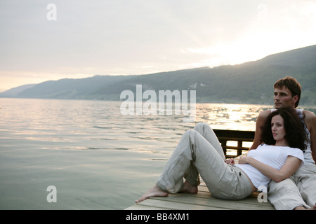 Un couple assis sur un ponton au bord de lac Banque D'Images