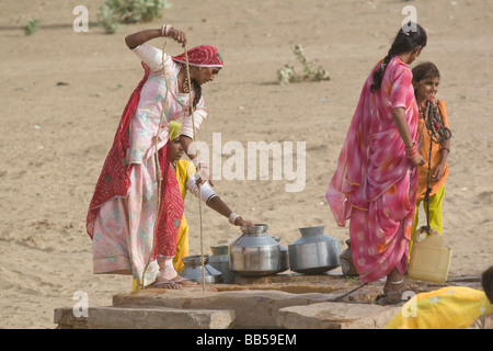 Inde Rajasthan La Mazurie les femmes et les filles portant de l'eau du puits au village Banque D'Images