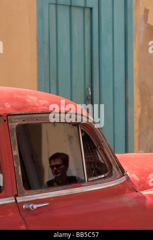 Portrait dans la fenêtre d'ancienne voiture rouge à La Havane, Cuba, Antilles, Caraïbes, Amérique Centrale Banque D'Images