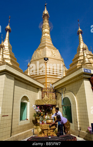 Les dévots verser de l'eau et en faisant des offrandes à Bouddha. Sule Paya. Yangon. Myanmar Banque D'Images