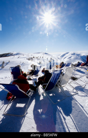 Les gens de vous détendre dans le haut de la station de ski de Valberg, dans un très beau panorama sur les sommets de neige en face d'eux Banque D'Images