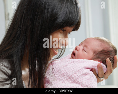 Mixed Race mother cuddling bébé nouveau-né Banque D'Images