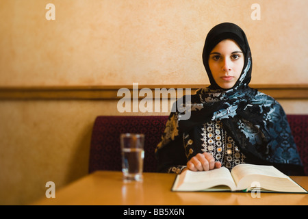 Adolescent moyen-orientale foulard en reading book Banque D'Images