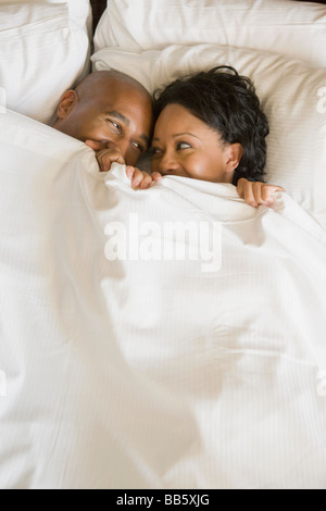 African couple au lit sous couverture Banque D'Images