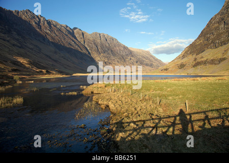 Ombre du pont sur le Loch Achtriochtan au pied du Col de Glencoe en début de soirée du soleil Banque D'Images