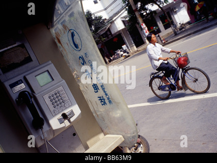 Téléphone chinois fort et d'une femme sur un vélo Banque D'Images