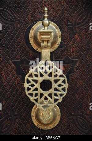 Détail/close-up of ornate metal heurtoir sur inticately porte en bois sculpté de style marocain typique, Erfoud, Maroc du Sud Banque D'Images