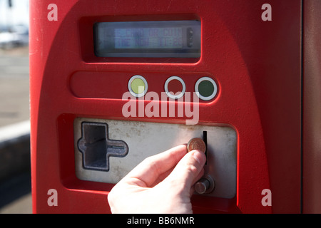 Man putting livre pièce dans payer et afficher machine parking au Royaume-Uni Banque D'Images