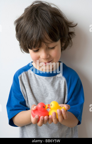 Petit garçon avec de petits canards en plastique Banque D'Images