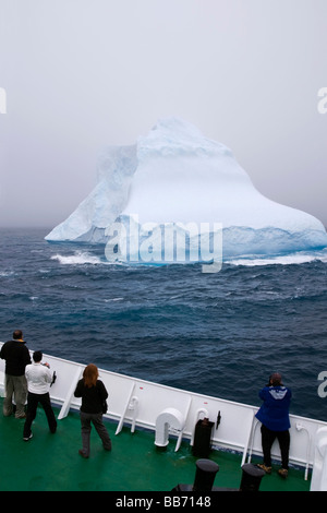 Les touristes à la recherche à un iceberg depuis le pont d'un bateau de croisière dans le sud de l'océan, près de l'Antarctique Banque D'Images