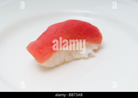 Une plaque blanche avec un morceau de Sushi de thon nigiri, sashimi, sur un lit de riz. Banque D'Images