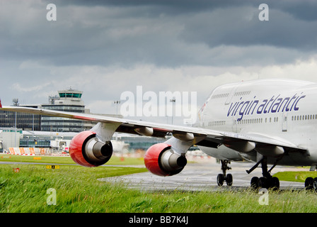 Un Boeing 747 de Virgin Atlantic Jumbojet le roulage à l'aéroport international de Manchester vers le terminal principal et la tour de contrôle. Banque D'Images