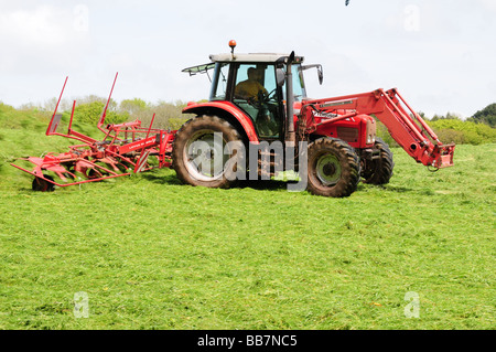 Le tracteur et l'ensilage fanage machine Bosherston Pwmbrokeshire Cymru Wales UK Banque D'Images