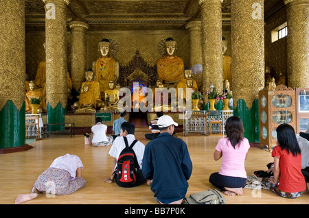 Debvotees adorant Bouddha. La Pagode Shwedagon. Yangon. Myanmar Banque D'Images