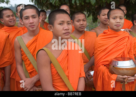 Les jeunes moines novices se préparent à sortir pour leur séance du matin d'aumône rassemblement à Wat Hay Sok à Vientiane, Laos. Banque D'Images