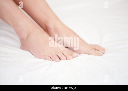 Portrait de jeune femme a pieds sur le linge blanc Banque D'Images