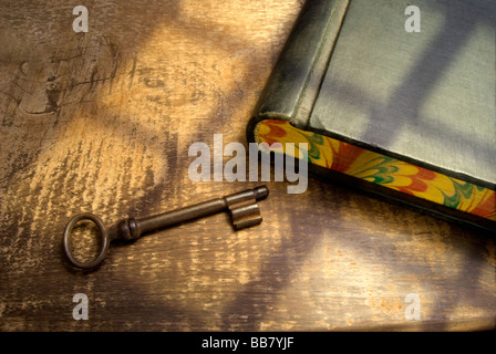 Ancienne clé et comptabilité livre, sur une table rustique, avec lumière provenant d'une fenêtre à proximité.ressemblant à l'atmosphère d'une ancienne scène. Banque D'Images