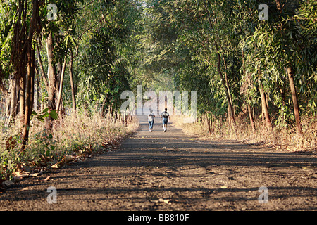 Un couple jogging sur une route isolée (Bombay) en Inde. Banque D'Images