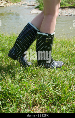 Caucasian blonde wearing repéré bottes en caoutchouc noir Banque D'Images