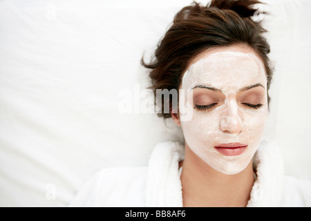 Portrait of young woman's face relaxant à visage pack et fermer les yeux Banque D'Images